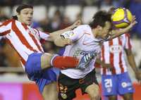 El colchonero Thomas Ujfalusi marca a David Silva, del Valencia, quien ayer anotó dos goles en la victoria 3-1 de su equipo ante el Atlético de Madrid