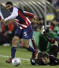 El jugador de Chivas Patricio Araujo roba el balón a Darío Botinelli