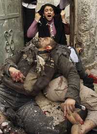 Una palestina mira impotente a su familiar muerto por un misil israelí que impactó en el poblado de Beit Lahiya.