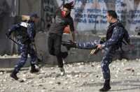 Elementos de seguridad palestinos golpean a un manifestante que lanzaba piedras durante una protesta en Belén contra la ofensiva israelí en Gaza