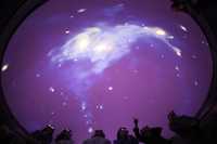 En el planetario Atmos, del Museo de Ciencia Emergente e Innovación, en Tokio, los visitantes observan en alta resolución detalles del cosmos en una proyección en 3D
