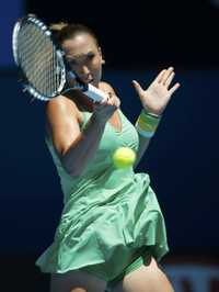 La serbia Jelena Jankovic devuelve una pelota a Yvonne Meusburger, de Austria, durante su encuentro en el Abierto australiano de tenis, en Melbourne