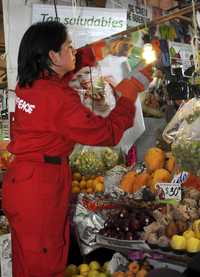 Una activista de Greenpeace durante una campaña para ahorrar electricidad en un mercado de la ciudad de México