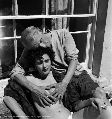 Fotografía: Lee Miller, 1938 Leonora está bajo una ventana, sentada y desnuda, posa despreocupada al sol, sus ojos se cierran por la intensa luz. Max la abraza por la espalda, sus fuertes y grandes manos cubren sus senos pequeños, ella fuma, él mira sin rumbo, al infinito.