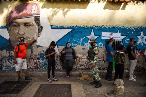 Votantes hacen fila en una mesa de votación ubicada en una escuela en Caracas.