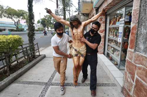 DÍAS DE FE. Empleados de una tienda cercana a la Basílica preparan una efigie para enviarla por paquetería, ya que la venta de esos artículos ha subido un poco.