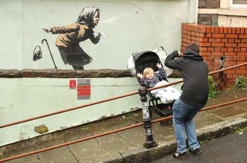 Un hombre inmortaliza a su pequeño hijo frente al nuevo mural.