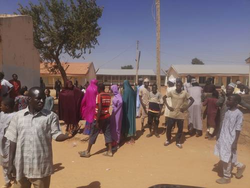 Padres de familia esperan en la Escuela Secundaria de Ciencias en Kankara, Nigeria, que las autoridades les informen sobre el paradero de sus hijos, luego de que un comando armado irrumpió en el plantel el viernes y secuestró a cientos de alumnos.