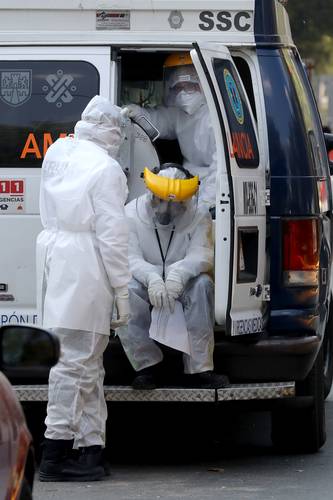 Rescatistas se toman un leve descanso luego de ingresar a un paciente más con síntomas de Covid al Hospital General de Zona 1-A en la Ciudad de México.