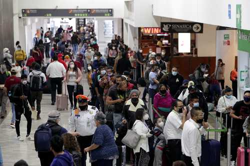 Con el semáforo epidemiológico en rojo, viajeros abarrotan el AICM.