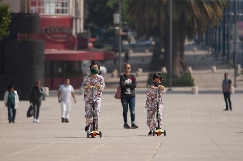 Niños juegan con patines en la explanada del Monumento de la Revolución en la Ciudad de México.