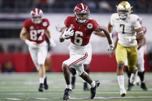 El receptor abierto DeVonta Smith (6) de Alabama Crimson Tide, elude a la defensa en la primera de sus tres anotaciones de ayer.