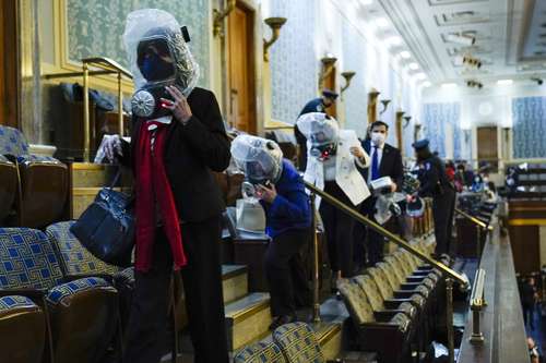 Personas se refugian en la galería de la Cámara, tras irrupción de manifestantes al Capitolio.