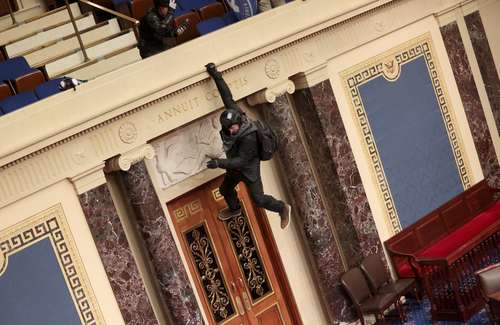 El 6 de enero pasado simpatizantes de Donald Trump irrumpieron en el Capitolio de Estados Unidos, en la imagen se ve a un activista colgado del balcón interior.