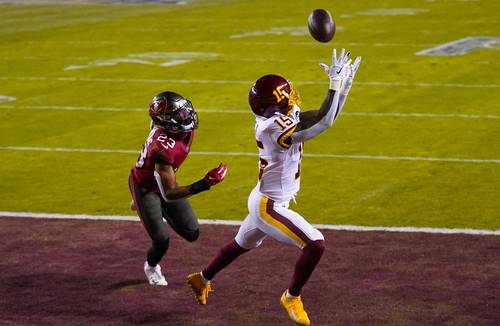 El duelo de comodines de la NFL quedó 31-23 a favor de los Bucaneros. En la foto, Steven Sims, de Washington, recibe el pase completo para anotación frente a Murphy-Bunting.