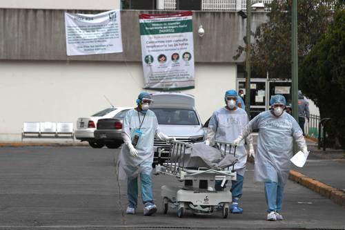 Personal de salud del hospital regional 24 de IMSS, en la alcaldía Gustavo A. Madero, traslada a un paciente fallecido en la zona Covid.