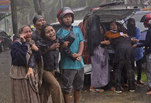 Familiares durante los trabajos de rescate en un edificio en el distrito de Mamuju, tras el movimiento de intensidad 6.2 que azotó la isla de Célebes, en Indonesia.