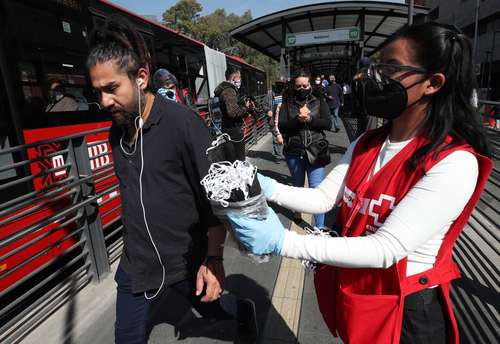  Voluntarios de la Cruz Roja ofrecen cubrebocas y gel antibacterial a transeúntes. Foto José Antonio López