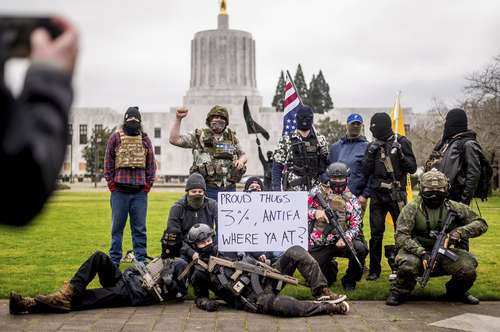 Manifestantes armados que se identificaron como miembros de Liberty Boys, posan afuera del Capitolio del estado de Oregon. El grupo declaró que quiere “un gobierno reducido” y no apoyan ni al presidente Donald Trump ni al mandatario electo, Joe Biden.