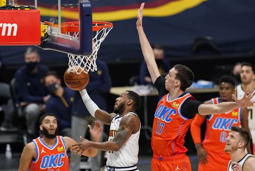 El escolta de los Nuggets, Monte Morris, al centro, se dirige al aro entre el jugador del Thunder de Oklahoma, Kenrich Williams, a la izquierda, y el alero Aleksej Pokusevski, en el partido de ayer en Denver.