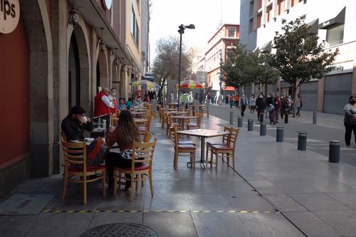 Para sobrevivir a la crisis, algunos restaurantes han colocado sillas y mesas en las aceras.