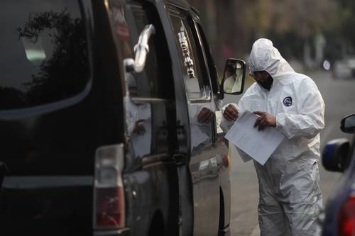  Carroza fúnebre espera el traslado de un cuerpo afuera del Hospital General Zona 1 A, en la capital. Foto Yazmín Ortega