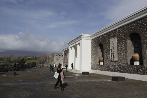  Nubes cubren el volcán Vesubio mientras periodistas caminan frente a la fachada del Anticuario. Foto Ap