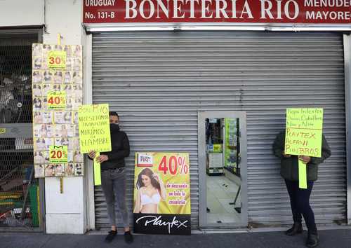 Comerciantes del Centro Histórico esperan la llegada de algún cliente durante el semáforo rojo.