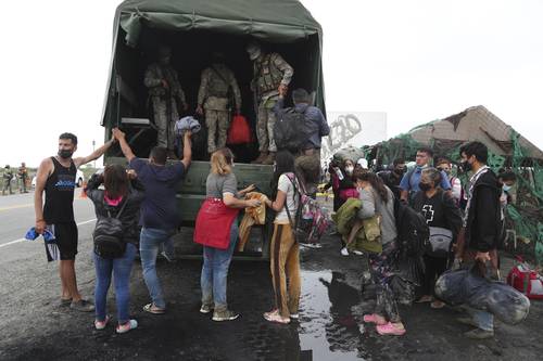 En Tumbes, Perú, migrantes venezolanos se preparan para ser transportados por el ejército de ese país hacia Ecuador.