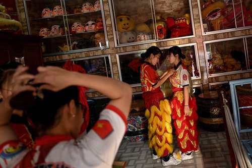 Bailarinas de la escuela de danza del león y el dragón Tu Anh Duong en la ciudad de Can Tho, Vietnam, se preparan para una sesión de práctica para perfeccionar las acrobacias que exhibirán durante el Tet, fiesta del Año Nuevo vietnamita, festival de colores en el que los distritos compiten en ingenio para ser los mejores con sus bailes y decoraciones, que comienza la próxima semana.
