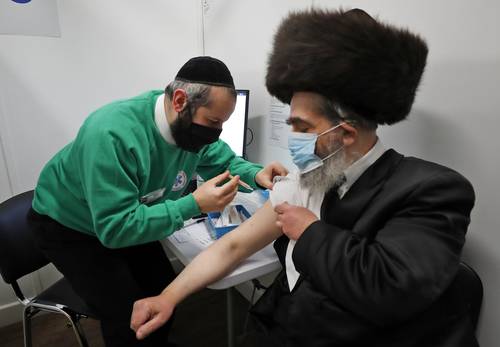En el Centro de Vacunación John Scott, en Londres, al rabino Bieberfeld se le administra una dosis de AstraZeneca para fomentar la adopción de la vacuna entre la comunidad judía ortodoxa haredí de Gran Bretaña.
