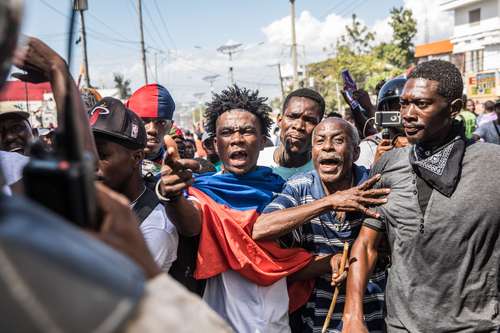 Manifestantes se enfrentan con policías ayer en Puerto Prín-cipe durante una marcha contra el gobierno de Jovenel Moise.