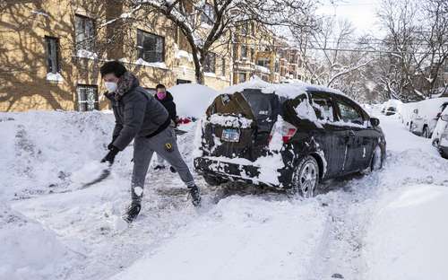 Residentes intentan sacar un automóvil en el vecindario de Lake View, Chicago, tras una tormenta de nieve.