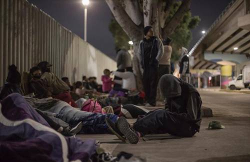 Migrantes durmieron este viernes en la explanada frente al Instituto Nacional de Migración, cerca del puerto fronterizo de El Chaparral, en Tijuana, en espera de respuesta de autoridades.