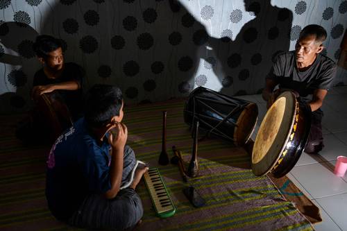 En Indonesia, Fajar Siddiq, artesano de panderetas que perdió su empleo por la pandemia, toca en las calles con sus hijos.