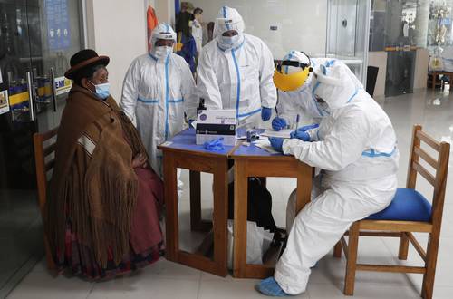 Trabajadores del sector salud toman datos de una mujer antes de hacerle pruebas de Covid-19, en la Escuela Militar de Ingeniería en La Paz, Bolivia. Las cuadrillas de atención a la pandemia están llegando a los lugares más apartados del planeta.