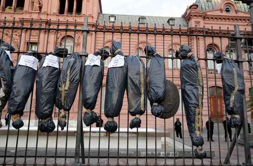 Participantes en una protesta contra el gobierno de Alberto Fernández colgaron bolsas que simulaban cadáveres en la reja de la Casa Rosada, en Buenos Aires.