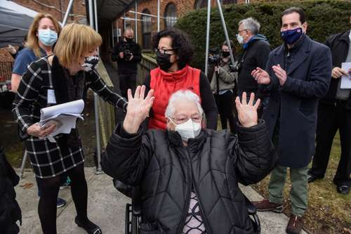 Un anciano celebra luego de recibir la inoculación anti-Covid en Lawrence, Nueva York.