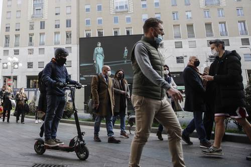 En Milán, una pantalla gigante transmite el desfile de modelos de Giorgio Armani de la colección otoño-invierno 2021-22.