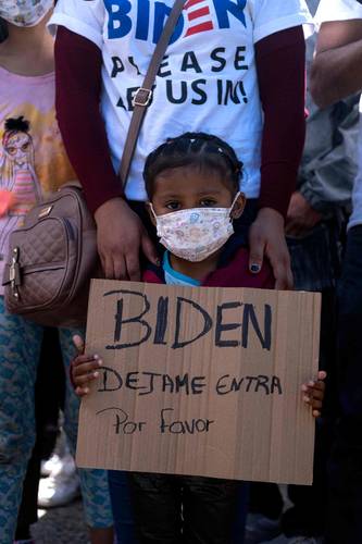 SÚPLICA A BIDEN EN LA FRONTERA. Niña hondureña pide al presidente de Estados Unidos que la deje entrar, durante una manifestación en la garita de San Ysidro, en Tijuana, Baja California, donde permanecen miles de migrantes que están fuera del programa de protección estadunidense.