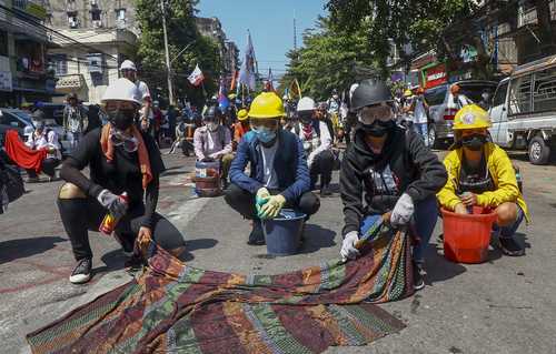 La Unión Europea suspendió la ayuda financiera a proyectos de desarrollo en Myanmar para evitar que llegue a los militares que tomaron el poder en febrero. En la imagen, manifestantes usan telas mojadas para protegerse del gas lacrimógeno, en Yangón.