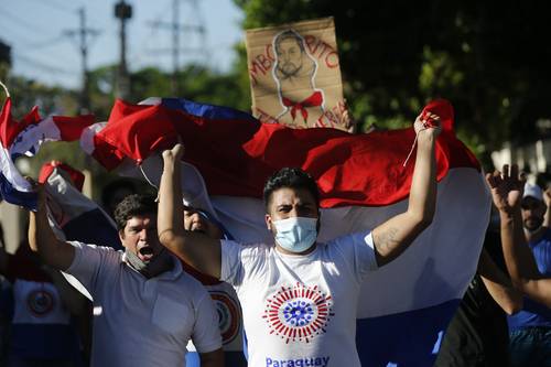 Manifestantes en Asunción corean consignas cerca de la residencia oficial del presidente Mario Abdo Benítez, a quien acusan de mal manejo de la pandemia de Covid-19.