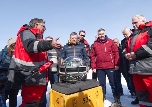 Científicos y funcionarios del Instituto de Investigación Nuclear de la Academia de Ciencias de Rusia observan cómo el equipamiento se sumerge en el agua del lago Baikal.