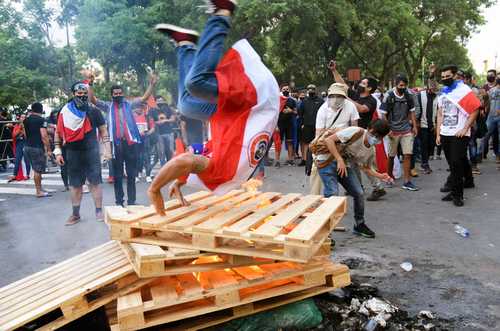 Pese a la escasez de vacunas y fármacos básicos para combatir al coronavirus, la Cámara de Diputados de Paraguay rechazó ayer el pedido de juicio político contra el presidente Mario Abdo Benítez por su mal desempeño durante la pandemia. En la imagen, opositores al mandatario se manifiestan mientras esperaban la votación del legislativo.