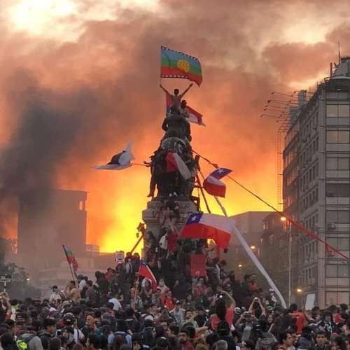 Sobre la multitud reunida en la Plaza de la Dignidad se alza un joven si camisa sobre la estatua de un héroe militar; entre el humo, ondea la bandera mapuche. Esta foto, la más icónica de las protestas en Chile, ilustra la portada del libro de Berenguer.