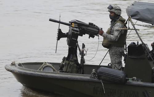 Integrantes de la armada colombiana vigilan el río Arauca, la frontera natural con Venezuela.