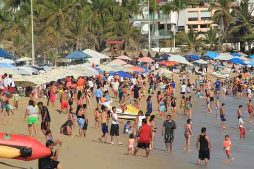 En la playa El Morro, en la zona Dorada de Acapulco, Guerrero, cientos de familias vacacionan desde el viernes. En ese sector del puerto se registró ayer una ocupación hotelera de 46.6 por ciento. Se espera el arribo de 300 mil turistas durante Semana Santa.