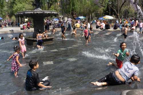 La fuente de la Alameda Central fue ayer uno de los puntos de encuentro de familias, donde los niños aprovecharon para darse un chapuzón y amainar el calor.