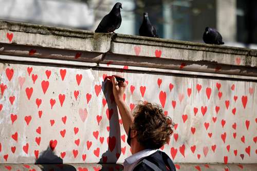 En memoria de las víctimas de Covid-19, familiares en duelo dibujaron a mano casi 150 mil corazones en una pared situada en el sur del río Támesis, en Londres.