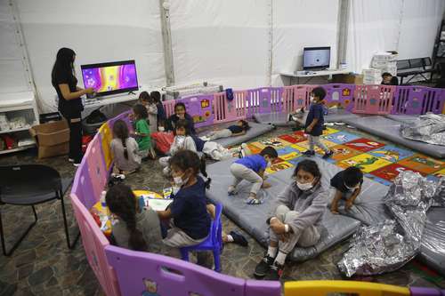 Supervisados por una adulta, niños migrantes no acompañados, de entre 3 y 9 años, permanecían ayer dentro de un corralito, en el centro de detención ubicado en el valle del Río Bravo, en Donna.